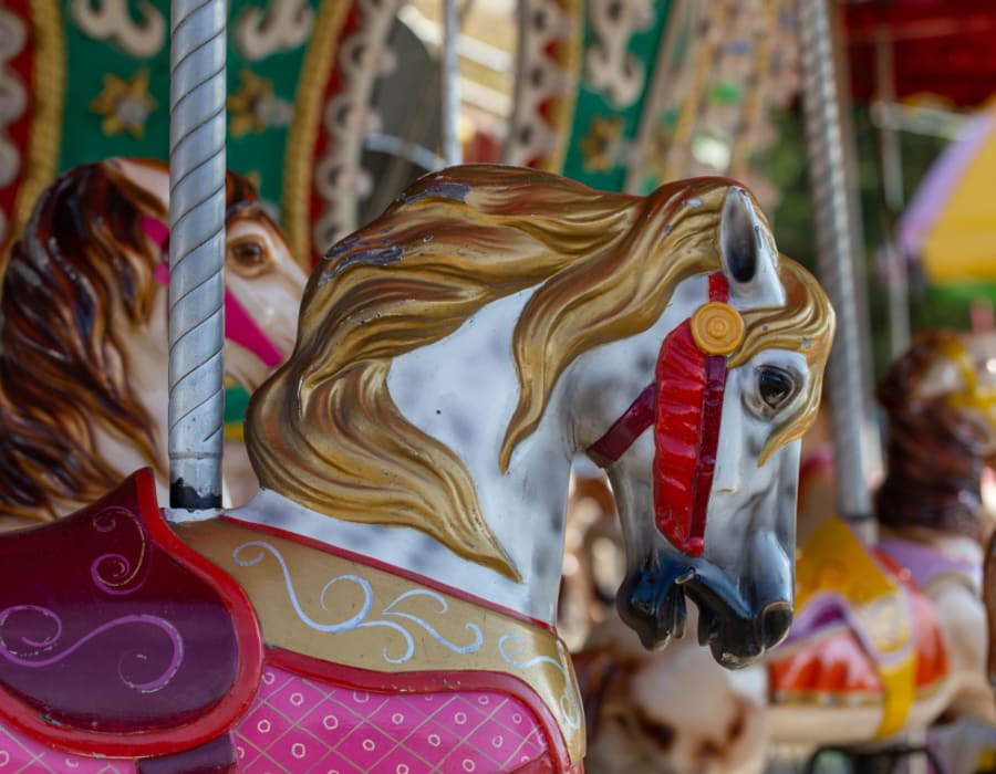 A brightly painted carousel horse at a family fairground